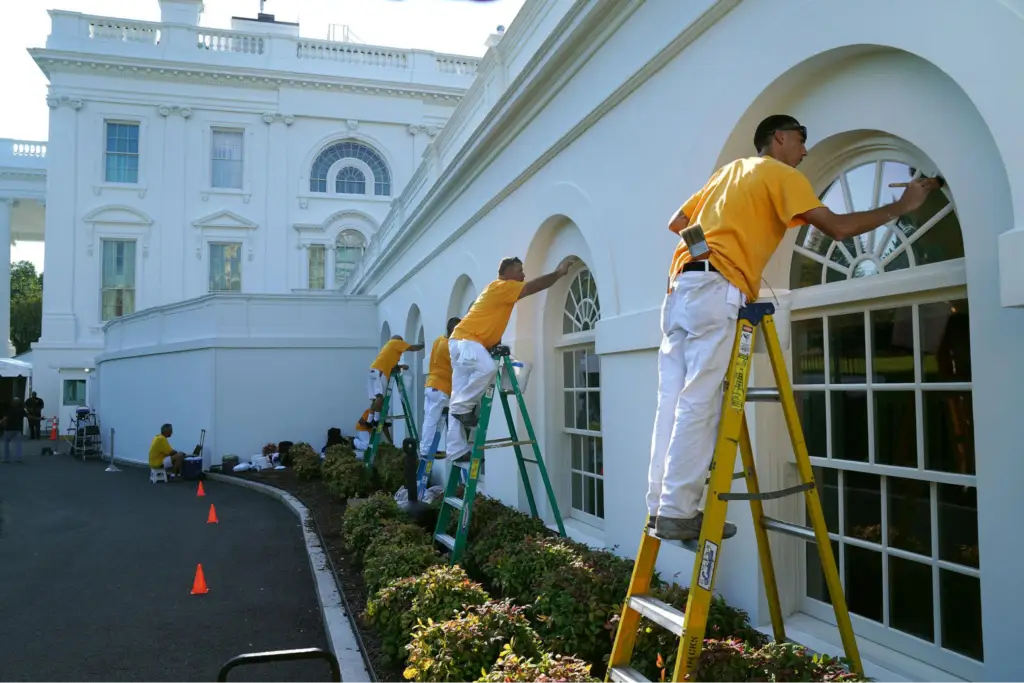 Professional painters applying exterior coatings to a government facility, showcasing detailed prep by an exterior painter in Burlingame, CA