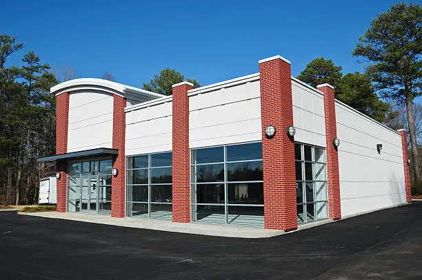 Building exterior with white facade panels and red brick columns by a painting company in Hillsborough, CA